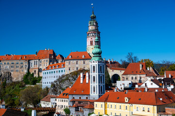 Obraz premium Panoramic view of Cesky Krumlov, featuring the historic castle tower and the church of St. John of Nepomuk. The medieval town's charm is beautifully captured on a sunny day