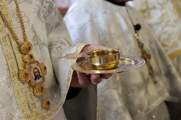 During the liturgy, the priest holds a cup of wine in his hand.
