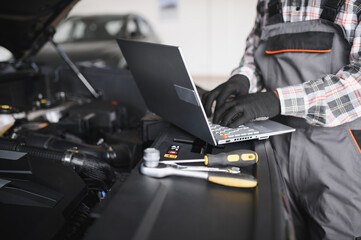 Fototapeta premium Automobile computer diagnosis. Car mechanic repairer looks for engine failure