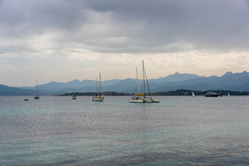 Fototapeta premium Sailing boats in the coast of Sardinia on a cloudy day in Italy