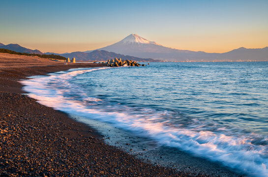 Mountain Fuji with wave crushing beach at sunrise view from Suruga Bay, Shizuoka, Japan