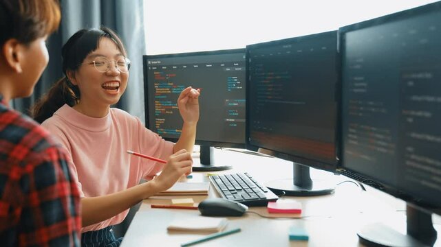 Slow motion back end software developer engineer for computer programming working together on debugging writing computing code, solving complex algorithms display on monitor in office. Burgeoning