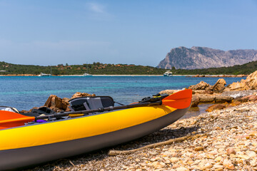 Kayak on ruja island beach with turquoise water with Salinedda beach and Molara island on the background in Sardinia, Italy