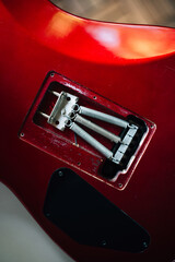 Red electric guitar body on guitar repair desk or in a repair work shop.