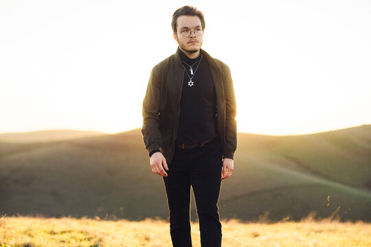 Young man wearing a star of david necklace standing in a rural landscape, Brushy Peak Regional Preserve, California, USA