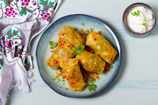 Stuffed cabbage leaves. Cabbage wraps or rolls. Chou farci, dolma, sarma, golubtsy or golabki on blue plate on green blue table. High angle view