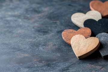 Fototapeta premium Wooden Hearts on Dark Background: A Symbol of Love, Unity, and Social Harmony