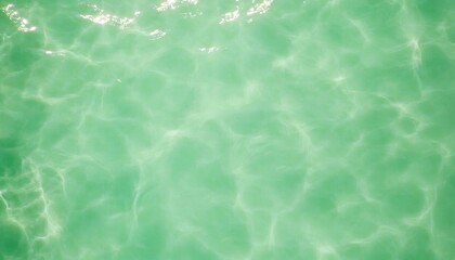 A serene view of turquoise water, showcasing gentle waves and sunlight reflections, creating a calming and refreshing ambiance.