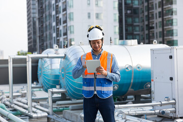 Male engineer work using digital tablet for checks or maintenance in sewer pipes area at...