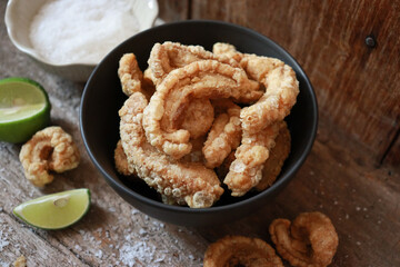 Bowl of crispy pork cracklings or pork rind. Asian food appetizer.