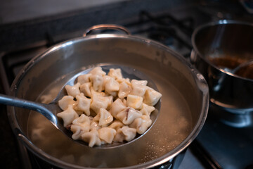 Traditional Turkish dish manti is being boiled in a pot.