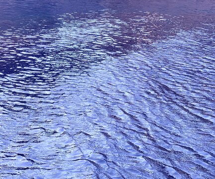 Blue water glittering ripples river surface