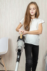 Little girl using vacuum cleaner in room