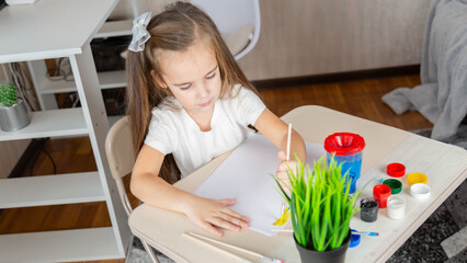 Child girl playing with digital wireless tablet computer on bed at home.