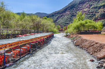 Ourika valley mountain river with rocks at front and hills at back.