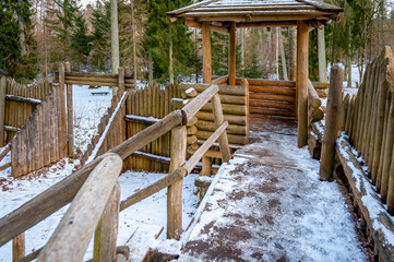 Wooden fortress wall against the forest. Wooden installation in the style of an ancient city. Stockade fence made of logs. Kartavkalna Nature Trail, Latvia.