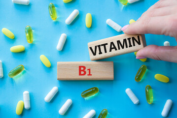 Vitamin B1 symbol. Concept word Vitamin B1 on wooden blocks. Beautiful blue background with pills. Doctor Hand. Medicine and Vitamin B1 concept. Copy space