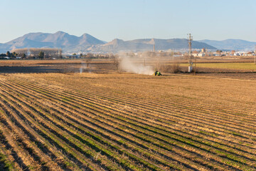 Vista de la vega de Granada con un tractor arando la tierra