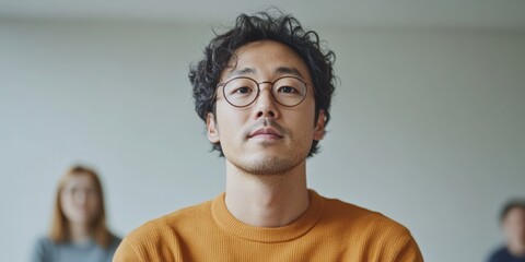 Obraz premium Modern Professional Portrait Young Asian Male in Casual Knitwear - Contemporary Office Branding and Social Media Engagement