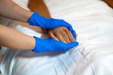Obraz premium hands of a nurse taking the hands of a very serious patient in the hospital