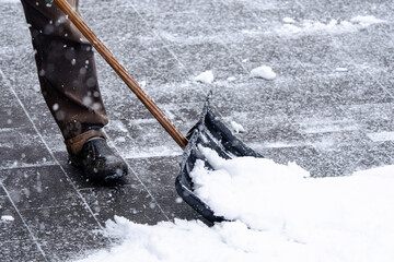 A man is shoveling snow with a snowplow