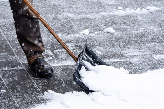 A man is shoveling snow with a snowplow