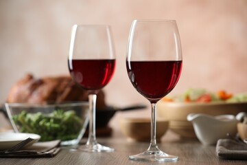 Red wine and delicious dinner served on wooden table