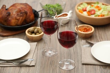 Red wine and delicious dinner served on wooden table