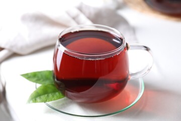 Refreshing black tea in cup on light table, closeup