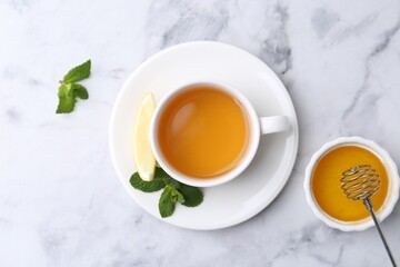 Aromatic mint, fresh leaves, lemon and honey on light marble table, flat lay