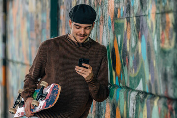 young man on the street with mobile phone and skateboard © carballo