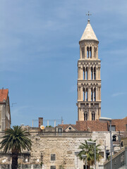 Fototapeta premium Split, Croatia - July 1, 2024: Coastal boardwalk. Saint Domnius Cathedral tower peeks over historic Diocletian's Palace walls.