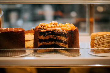 Cake displayed in a pastry shop showcasing layers and decorative toppings during the afternoon hours
