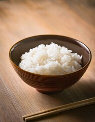 Red japanese lacquer bowl filled with boiled white rice and chopsticks on the table.