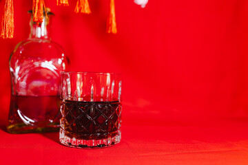 Chinese New Year Concept, Whiskey Glass On Red Background.