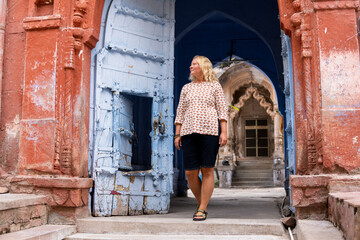 Young blonde woman discovering traditional blue houses of Jodhpur old town in Rajasthan, India