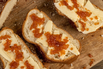 a soft loaf of wheat flour with butter and red salmon caviar