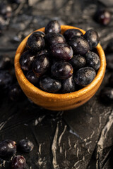 fresh grapes are lying on black paper