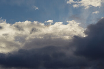 Blue sky with heavy gray clouds foretelling a weather change.