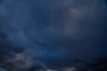 Dark storm clouds rise above the horizon, heralding rain.