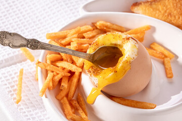 Soft-boiled egg, croutons and French fries on the kitchen table,top view