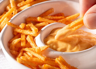 A plate of French fries with cream sauce on top