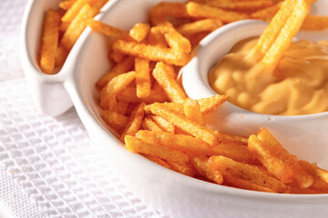A plate of French fries with cream sauce on top