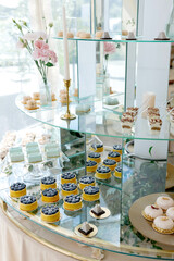 Delicious pastries and cakes decorating a glass tiered stand at a wedding reception