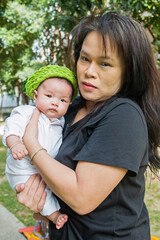 paternal grandmother and granddaughter on grass field