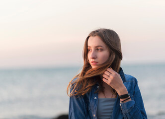 a young girl stands against the backdrop of the sea