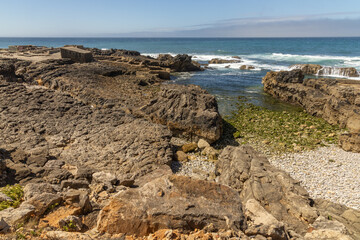Rock cliff coastline with a small bay the atlantic ocean in the background in Cascais Portugal.