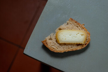 A slice of traditional Alentejo bread topped with a piece of creamy Alentejo cheese, showcasing the region's authentic and rustic flavors. Perfect for food and regional cuisine content.