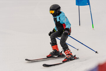 Children skiers ski in the Dolomites Alps. Group of people skiing in the mountains on a sunny winter day. Ski lessons with local instructors. Children learn to ski with an instructor.