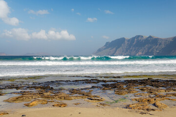 The beach Playa at La Caleta de Famara. Lanzarote, Canary Islands. Looking to cliffs of Risco de Famara